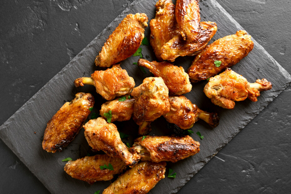 Grilled Chicken Wings On Black Stone Background. Top View, Flat Lay