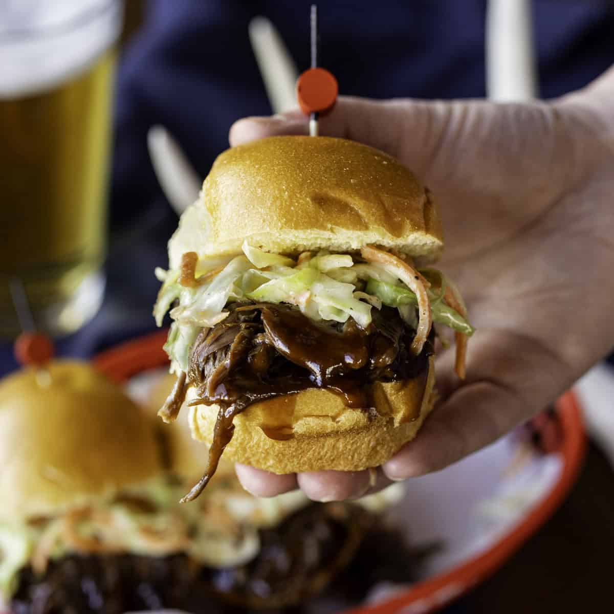 Hand Holding Bbq Venison Slider With Coleslaw 1200×1200 1.jpg
