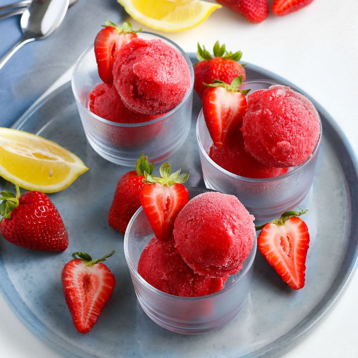 Strawberry Sorbet In Three Small Glasses On Gray Plate With Halved Strawberries As Garnish Square.jpg